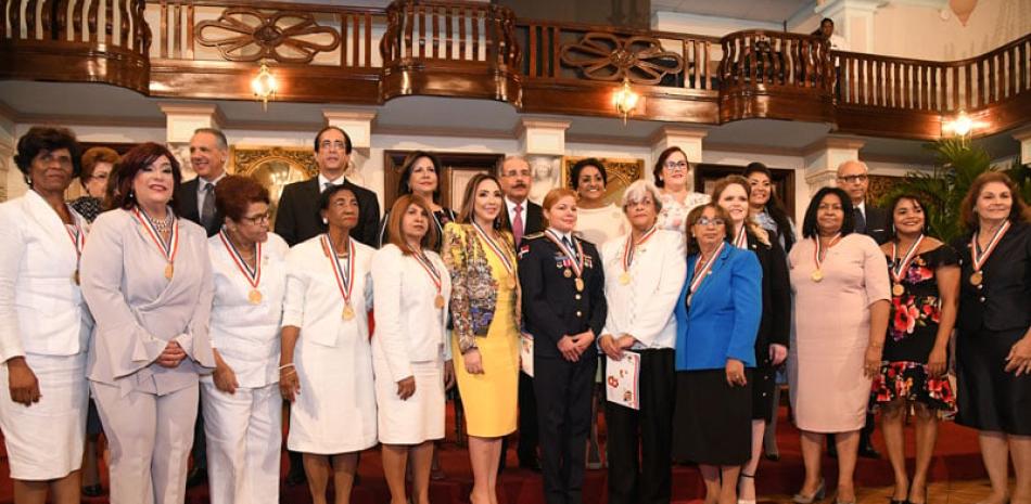 El presidente Danilo Medina junto a funcionarios de su gobierno y 14 damas reconocidas ayer en el Palacio Nacional, con ocasión del Día Internacional de la Mujer.