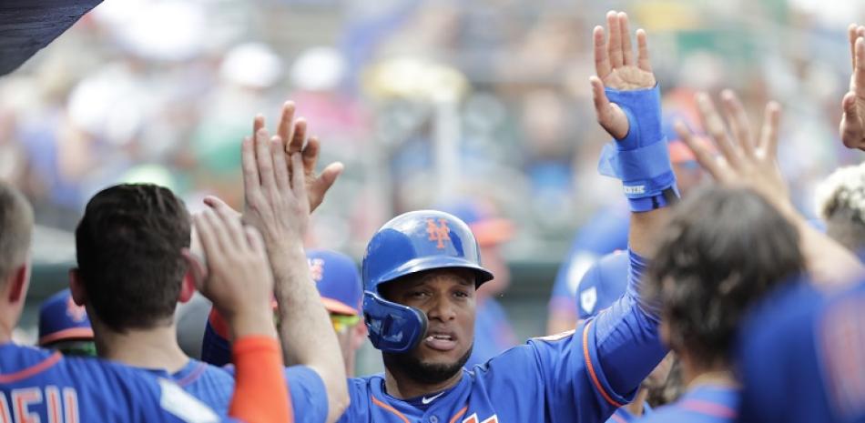 Robinson Canó es felicitado por sus compañeros de los Mets de Nueva York tras anotar una carrera en el partido de exhibición contra los Marlins de Miami.