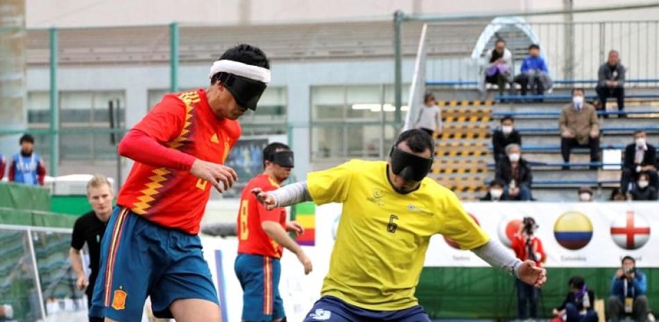 Jugadores de España y Colombia luchan por el control del balón en un partido del mundial de fútbol para ciegos.