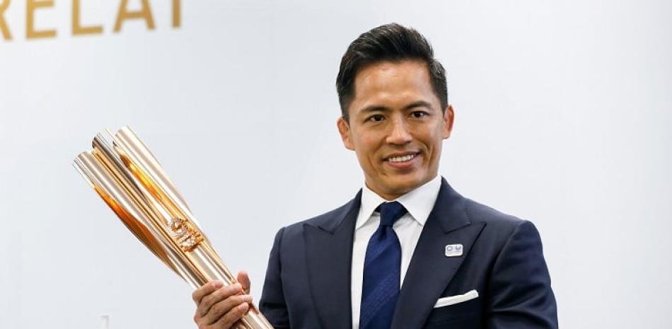Tadahiro Nomura, tricampeón olímpico de judo, exhibe la antorcha olímpica de los Juegos de Tokio 2020 durante la ceremonia de presentación.