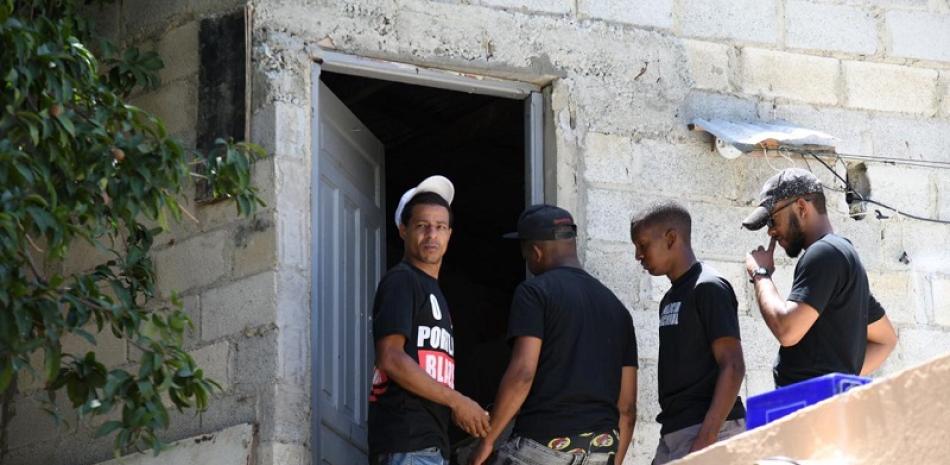 Los hijos de Bernardo mientras entraban en la residencia de su padre en Los Mina. Foto Raúl Asencio.