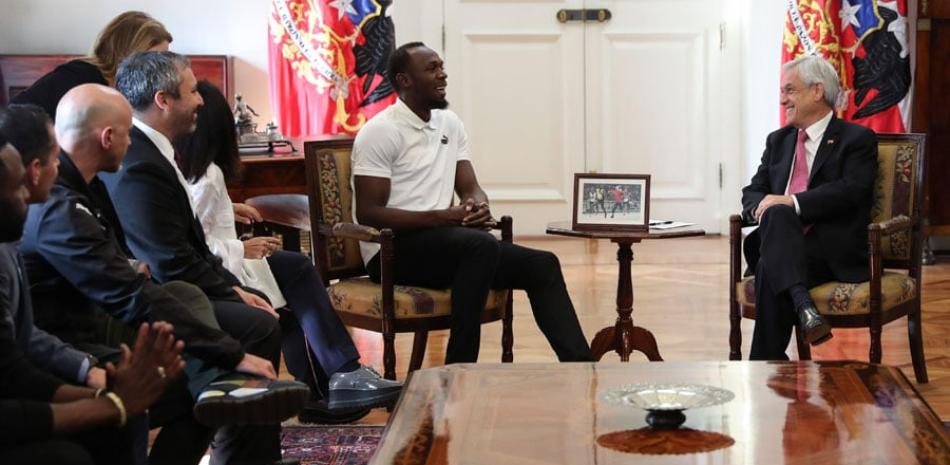 El atleta Usain Bolt (izquierda) conversa con el presidente de Chile, Sebastián Piñera (derecha), durante un encuentro celebrado este lunes en el Palacio de La Moneda. /EFE