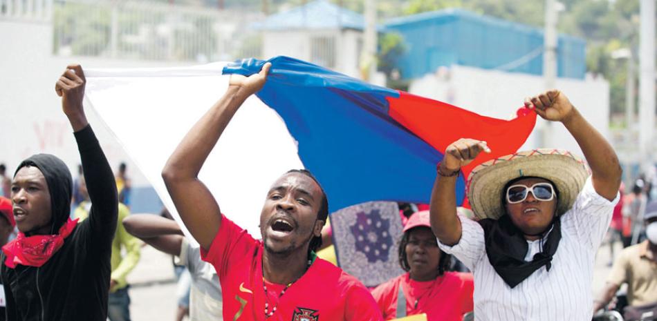 Manifestantes muestran una bandera rusa, en una protesta en Puerto Príncipe. AP
