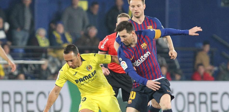 El delantero de Barcelona Lionel Messi trata de controlar el balón entre la defensa de Villarreal, durante el partido de ayer en el Ceramica stadium, en Villarreal, España. AP