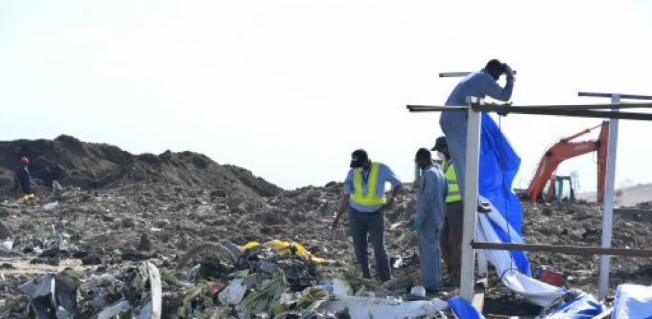 Miembros de los servicios de rescate que inspeccionan restos del fuselaje del Boeing 737 Max 8 de Ethiopia Airlines siniestrado cerca de Bishoftu (Etiopía).