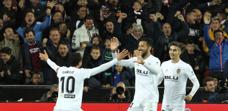 Ezequiel Garay, de Valencia, celebra con sus compañeros de equipo luego de anotar el segundo gol de su equipo. AP