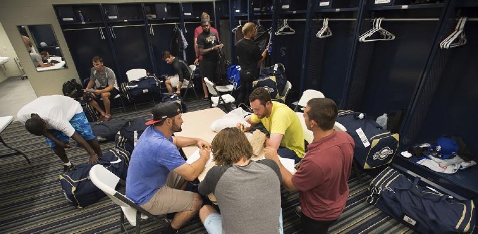 Integrantes de los Shuckers de Biloxi, un equipo de las ligas menores de béisbol, desayunan antes de la práctica en el estadio de Pensacola Blue Wahoo.