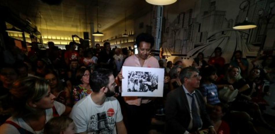 Asistentes participan de la subasta de medio centenar de fotografías firmadas por Luiz Inácio Lula da Silva y que retratan momentos históricos de su vida. AP