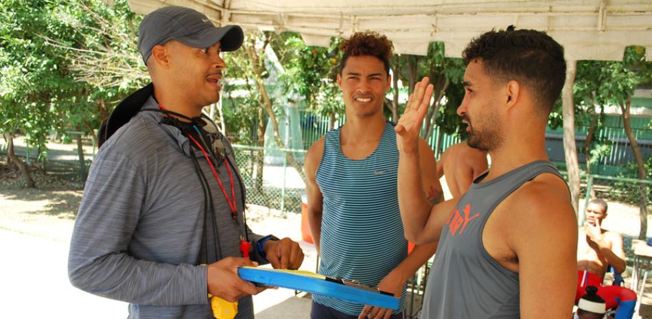 Félix Sánchez conversa con los hermanos Luguelín y Juander Santos, al finalizar los entrenamientos. Ambos velocistas enrenan bajo la tutela del Súper Sánchez.