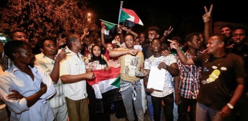 Los manifestantes sudaneses se manifiestan con banderas nacionales y corean consignas durante una manifestación contra el nuevo consejo militar gobernante establecido después del derrocamiento del presidente Omar al-Bashir, en la capital, Jartum.
