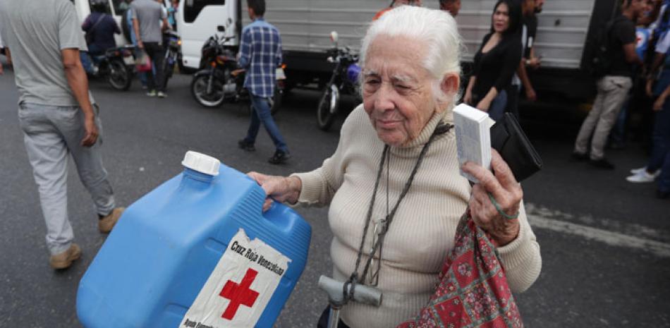 Una anciana recibe una caja del primer cargamento. EFE