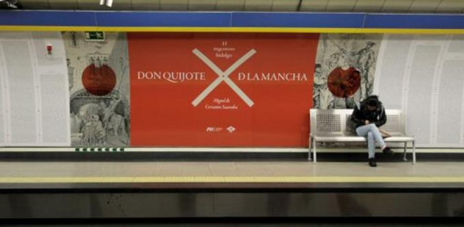 Una usuaria del Metro de Madrid junto a un vinilo que ha convertido a la línea tres en un libro abierto, que reproduce el texto completo de "El ingenioso hidalgo Don Quijote de la Mancha". EFE/Carlos Pérez