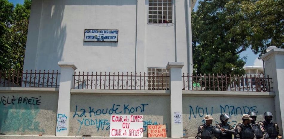 Miembros de la Policía son vistos durante una manifestación este viernes, ante la Corte Superior de Cuentas en Puerto Príncipe (Haití). Foto EFE.