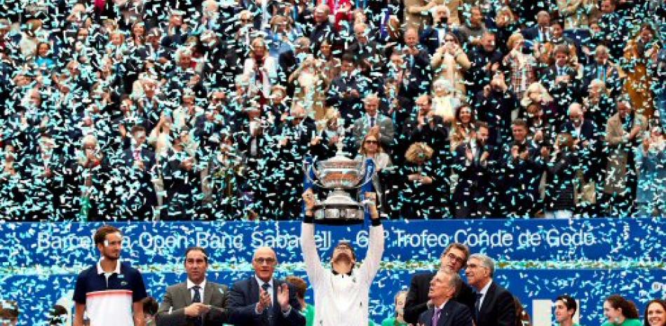 El tenista austríaco Dominic Thiem (c) levanta el trofeo tras vencer en la final del Open Banc Sabadell-Trofeo Conde de Godó al ruso Daniil Medvédev. EFE/Alejandro García