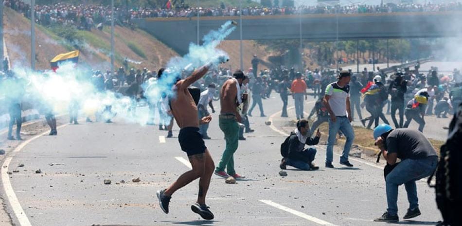 Simpatizantes de Juan Guaidó se enfrenta a la Policía Nacional Bolivariana, durante una manifestación de apoyo al levantamiento, en la Avenida Francisco Miranda. AP