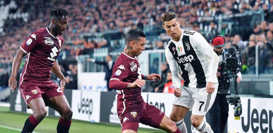 Cristiano Ronaldo y Armando Izzo se disputan un balón durante el partido de fútbol de la Serie A de Italia. EFE
