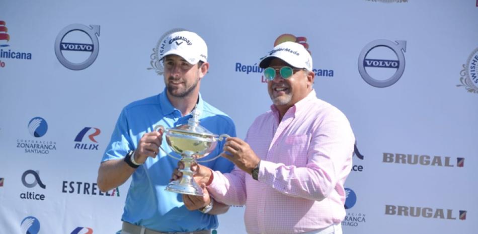 Augusto Reyes, presidente de Playa Dorada Golf Course, entrega la copa de campeón al ganador del Puerto Plata Open PGA Tour LA, Cristóbal Del Solar. EFE / AFP