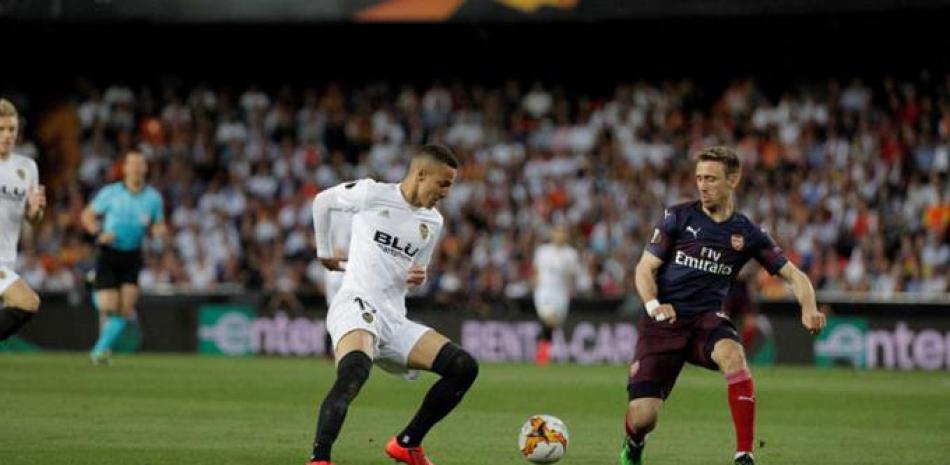 El jugador Rodrigo, del Valencia y Monreal, del Arsenal, se disputan el balón.