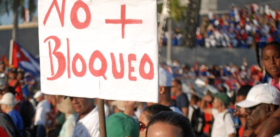 Imagen del 1 de mayo de 2019, de una mujer sosteniendo un cartel durante un desfile por el Día Internacional de los Trabajadores, en La Habana, Cuba. Políticos, funcionarios y académicos cubanos han reaccionado con enérgico rechazo a la activación total por parte de Estados Unidos de la Ley Helms-Burton, que desde 1996 codifica el entramado legal del bloqueo impuesto a la isla hace más de medio siglo por la Casa Blanca. (Xinhua/Joaquín Hernández)