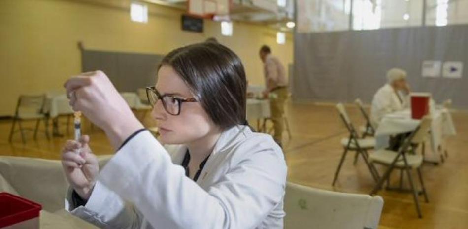 Estudiante de farmacéutica de la Universidad de Pittsburgh Alexandria Taylor preparando una jeringa durante una clínica gratis de vacunación contra el sarampión. / AP