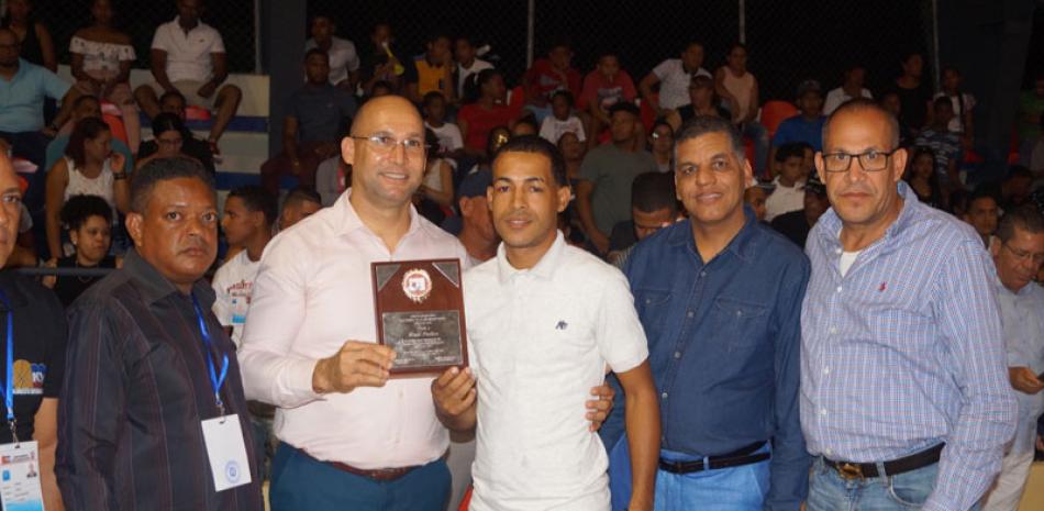 José Luis Rodríguez y Emilio Goris entregan a Enyer Paulino una placa como dirigente del año.