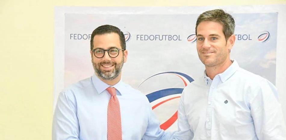 Manuel Luna estrecha las manos a David González, el nuevo director técnico de la selección nacional absoluta de futbol de República Dominicana.