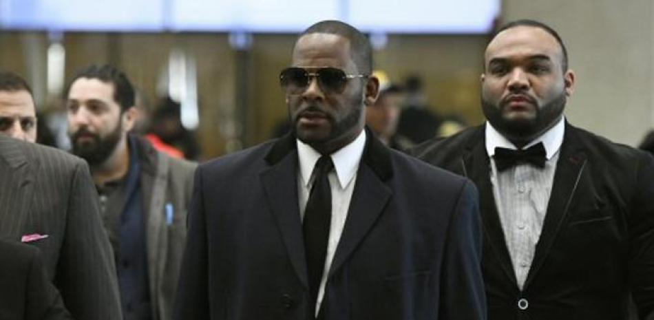 El cantante R. Kelly, en el centro, llega a un juzgado en Chicago para una audiencia el martes 7 de mayo. Foto AP.