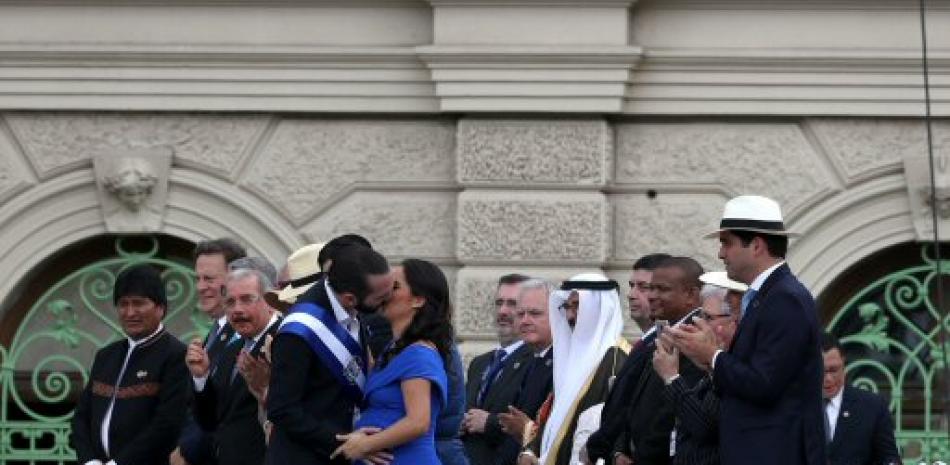 El presidente Bukele besa a su esposa embarazada en el acto de toma de posesión.