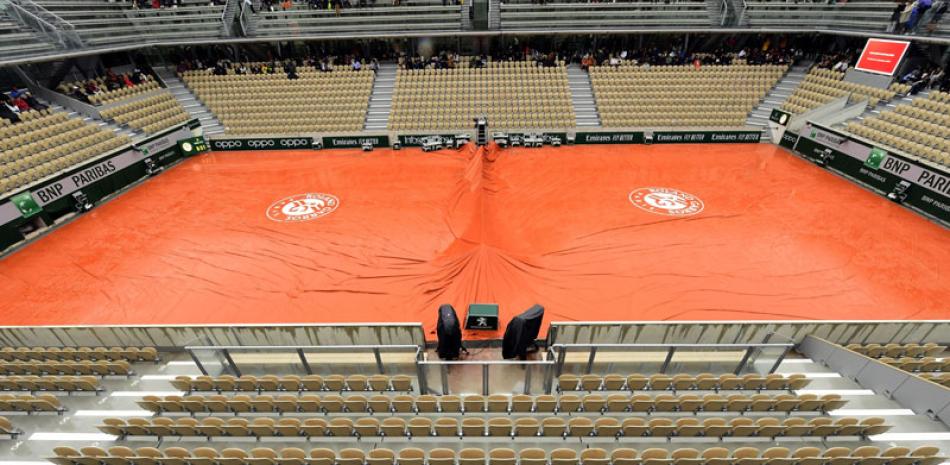 Imagen que muestra una de las pistas del torneo de Roland Garros cubierta a causa de la lluvia.