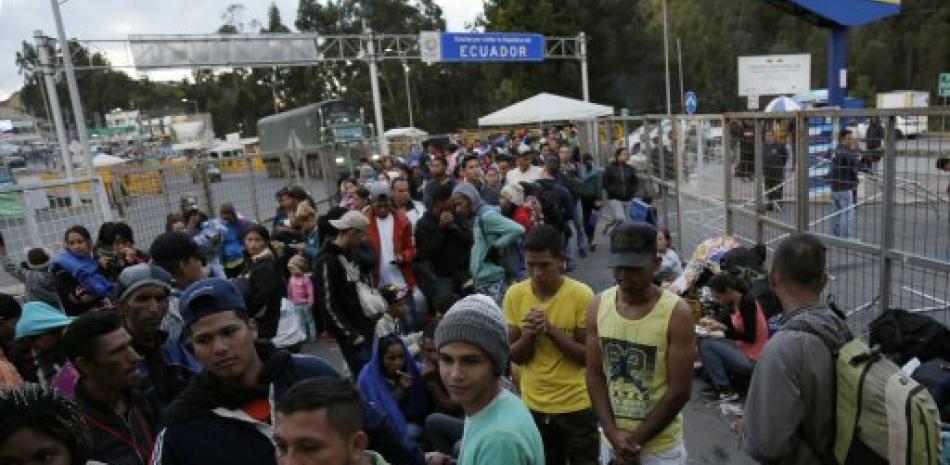Los venezolanos esperan afuera de una oficina de procesamiento de inmigración en el puente Rumichaca después de cruzar la frontera de Colombia a Rumichaca, Ecuador. Foto AP.