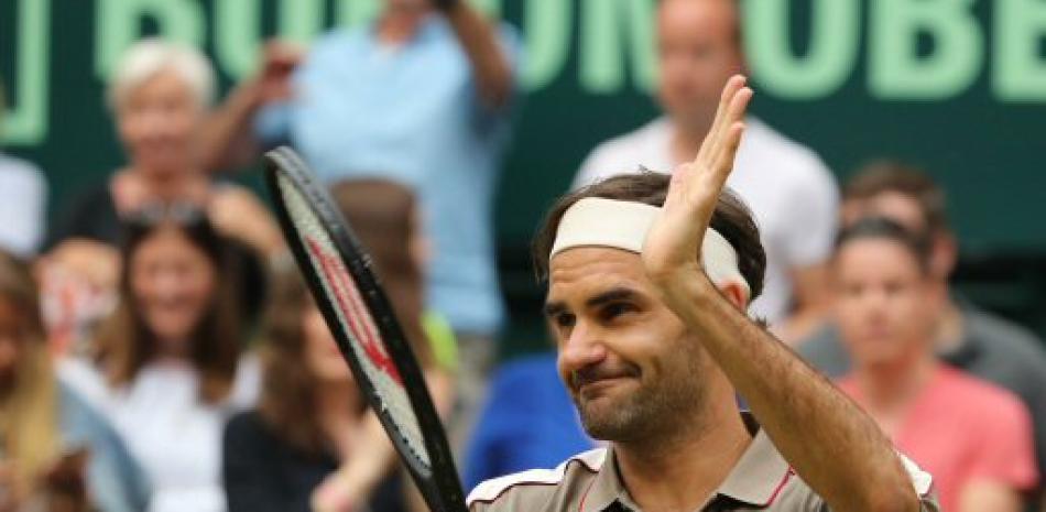 Roger Federer levanta su brazo luego de derrotar a Tsonga en un muy disputado partido
