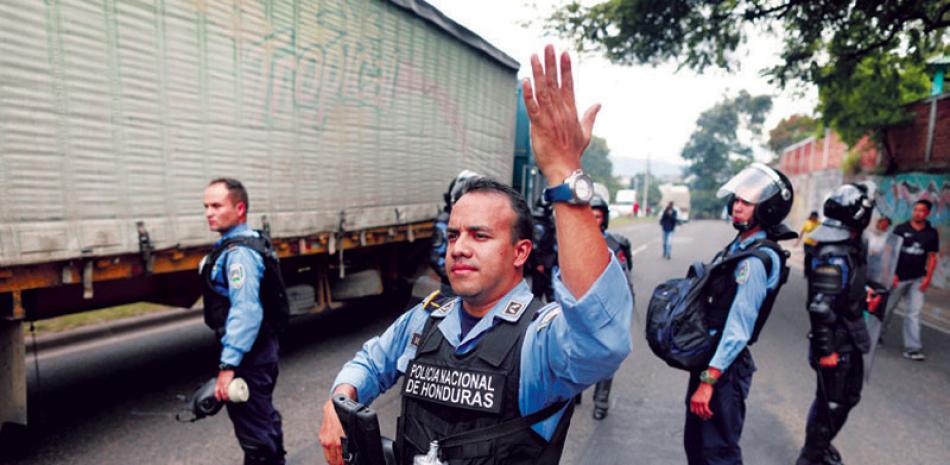 Policías agilizan el tráfico en protestas. AP