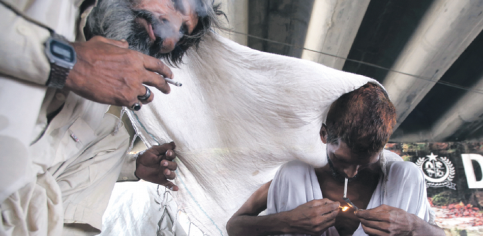 Drogadictos pakistaníes toman heroína en Karachi, ayer. Pakistán celebra hoy miércoles el Día Internacional contra el Abuso de Drogas y el Tráfico Ilícito. AP