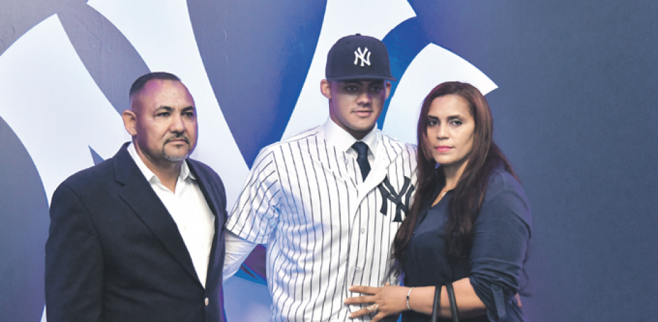 Jasson Domínguez figura junto a sus padres durante la presentación oficial como nuevo miembro de los Yankees, equipo que lo convirtió en el jugador en recibir la mayor cantidad de dinero en Julio 2. GLAUCO MOQUETE/LISTÍN DIARIO