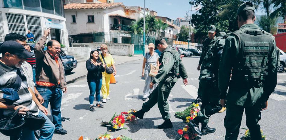 Militares patean las ofrendas colocadas a la entrada del Comando de la Armada
Bolivariana el martes, en honor al capitán asesinado Rafael Acosta Arévalo. EFE