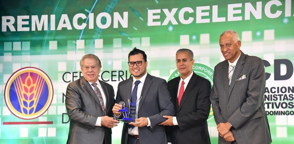 Williams Aish es galardonado por el inmortal Rolando Sebelén y Américo Cabrera, presidente de la ACDS. Observa el ingeniero Bienvenid Solano.