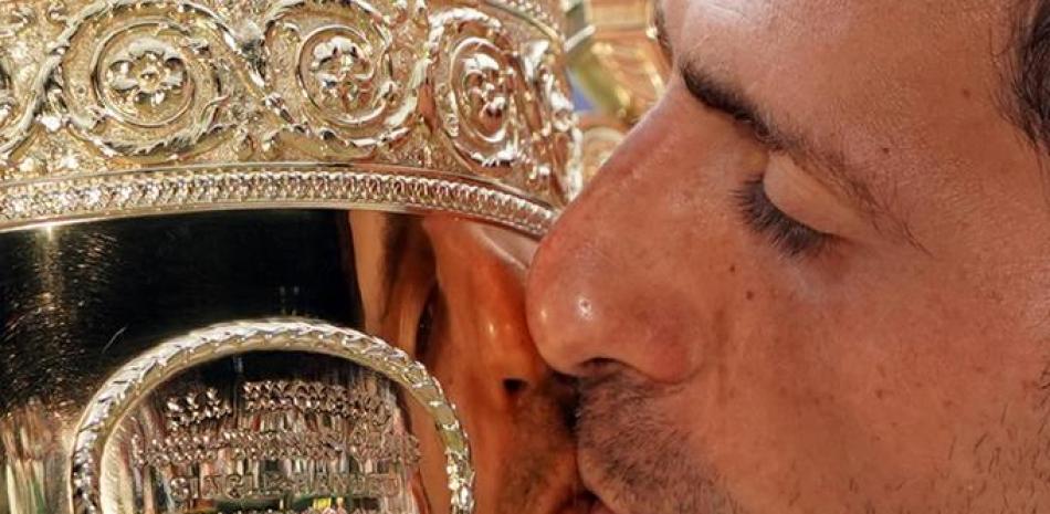 Novak Djokovic besa el trofeo del campeonato luego de derrotar a Roger Federer de Suiza en la final masculina del Campeonato de Wimbledon. EFE