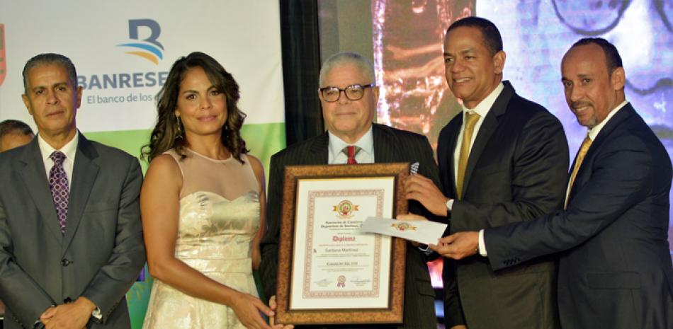 Santana Martínez, es galardonado por Julio César Valentín, senador por Santiago; Licandro Pérez y Yudith Hernández. Observa Américo Cabrera.FUENTE EXTERNA