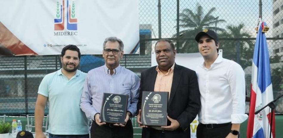 El Ministro de Deportes y Lucho Pou, presidente del Club Naco, reciben sus placas de reconocimientos. Figura el atleta Luis Delegado