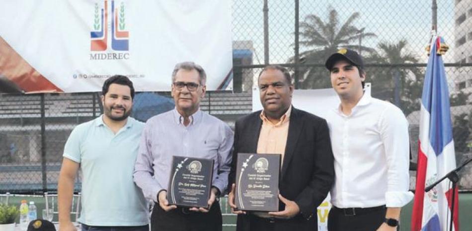 Danilo Díaz y Lucho Pou reciben sus placas de reconocimientos. Figura el atleta Luis Delegado.