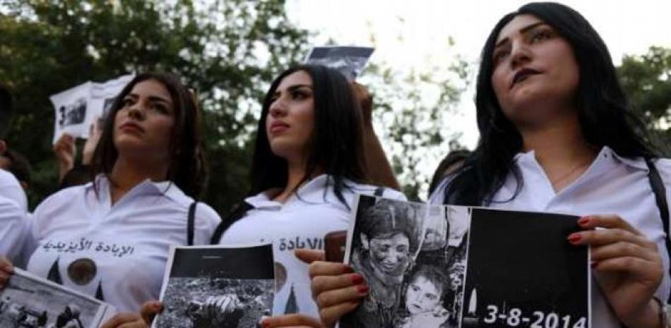 Mujeres yazidíes con pancartas recordando las víctimas de la ofensiva en 2014 del grupo yihadista Estado Islámico.© SAFIN HAMED
