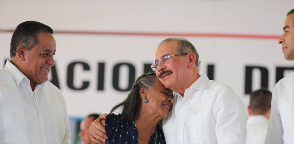 El director del IAD y el presidente Danilo Medina con una parcelera beneficiada. PRESIDENCIA
