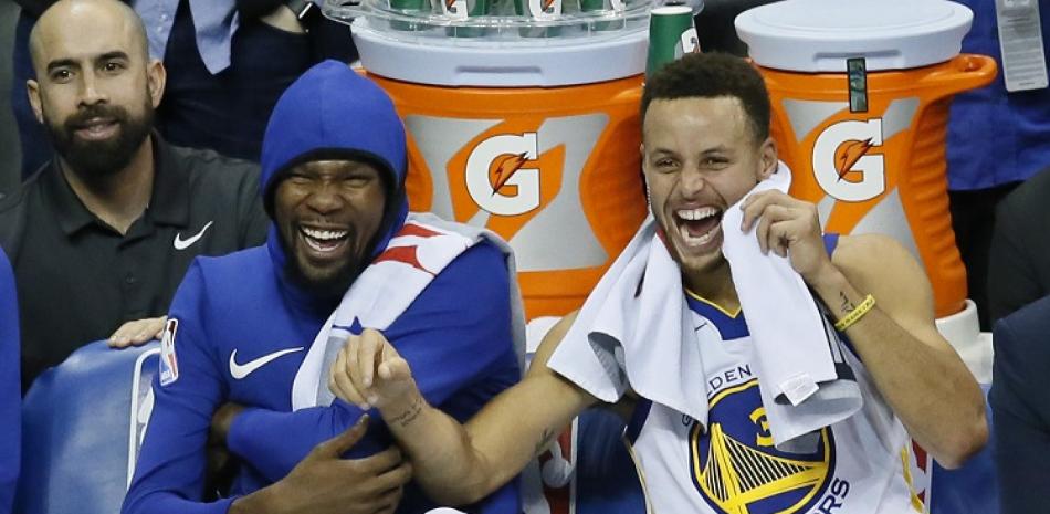 Stephen Curry, a la derecha, junto a Kevin Durant celebran en la banca durante un partido de los Warriors de Golden State.