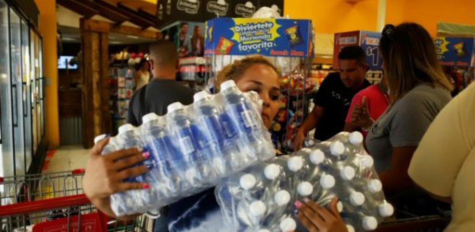 Personas abarrotan los supermercados en busca de agua. Foto AP.
