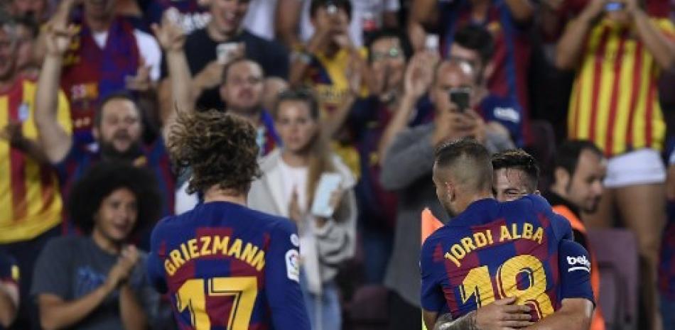 Carles Pérez (derecha) celebra con sus compañeros del FC Barcelona Jordi Alba y Antoine Griezmann después de anotar contra el Real Betis. Josep Lago/AFP.