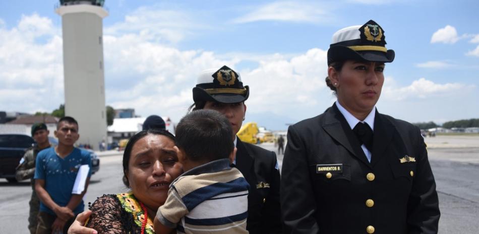 Familiares de uno de los soldados asesinados en el municipio de El Estor, departamento de Izabal, reaccionan a la llegada de sus ataúdes a la Base de la Fuerza Aérea en la Ciudad de Guatemala.