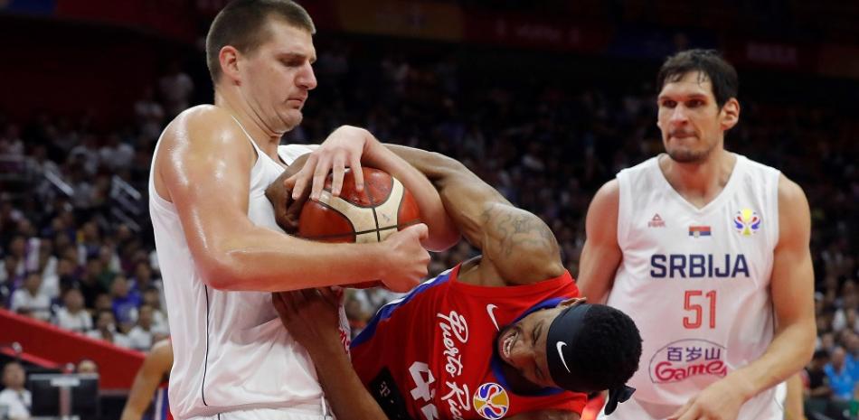 El serbio Nikola Jokic (i) pelea la posesión del balón ante su rival, el alero puertorriqueño Alexander Franklin (c) este viernes durante el partido celebrado en Wuhan (China) entre Serbia y Puerto Rico, del Grupo J, en la segunda fase del Mundial de Baloncesto de China