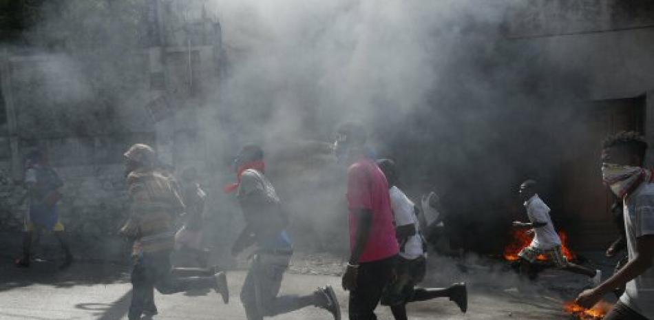 Haitianos corren por las calles de Puerto Principe durante las protestas. Foto: AP.