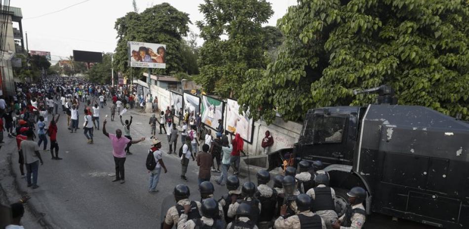 La policía impide que manifestantes se acerquen a la casa del presidente Jovenel Moïse, en Puerto Príncipe, Haití, el domingo 13 de octubre de 2019. (AP Foto/Rebecca Blackwell)