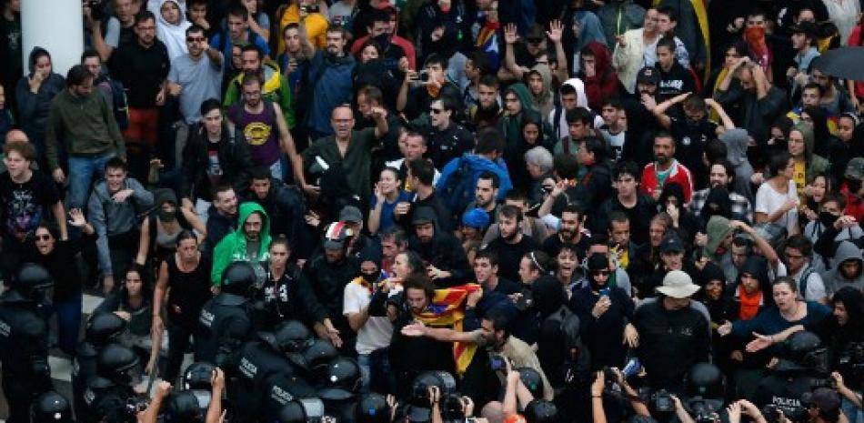 Manifestantes se enfrentan con policías españoles frente al aeropuerto de El Prat en Barcelona el 14 de octubre de 2019, cuando miles de manifestantes enojados salieron a las calles después de que la Corte Suprema de España condenó a nueve líderes separatistas catalanes  entre 9 y 13 años de cárcel por sedición por la fallida oferta de independencia de 2017. Pau Barrena/AFP.
